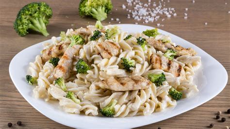 Plato de pasta con pollo, verduras y salsa