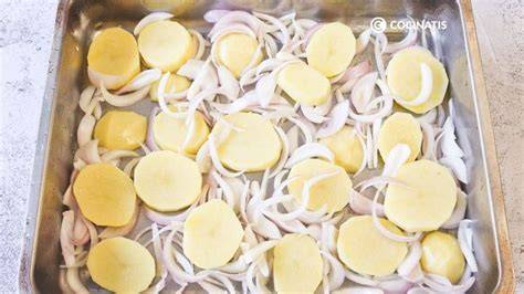 Codillos sobre cama de patatas y cebolla listos para hornear