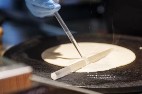 Chef preparando crepes en una plancha profesional