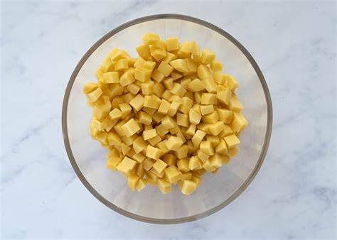 Patatas fritas en dados dorándose en aceite