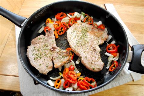chuletas de cerdo dorándose en sartén