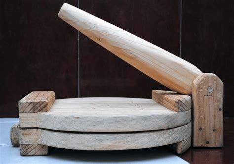 Prensa de tortillas de madera con una tortilla recién formada