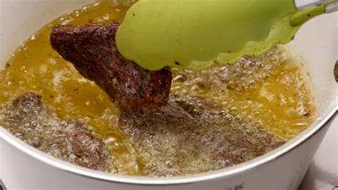 Carne siendo cocinada lentamente en una olla con salsa