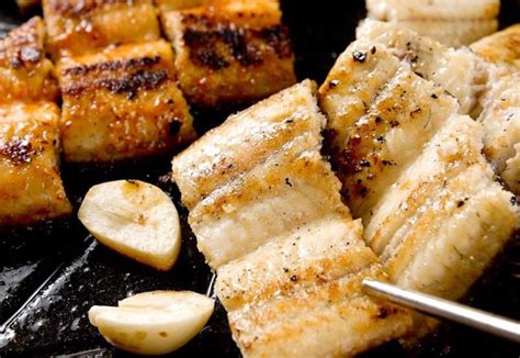 Detalle de anguila frita con ajo y guindilla