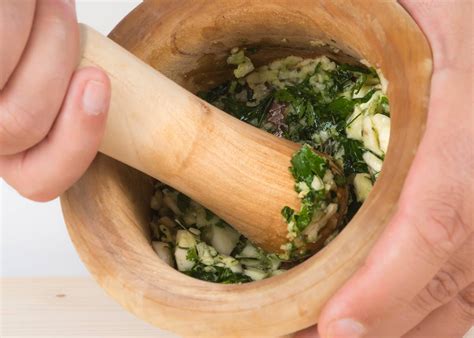 Mortero con los ingredientes para el majado de ajo y perejil