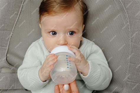 Bebé bebiendo leche de un vaso
