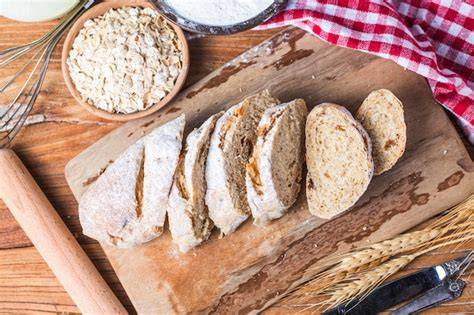 Pan artesano de espelta y avena recién horneado sobre una tabla de madera