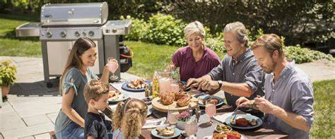 Familia disfrutando de una barbacoa de gas en un jardín