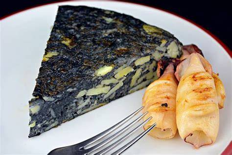 Fotografía de una tortilla de patatas negra con chipirones