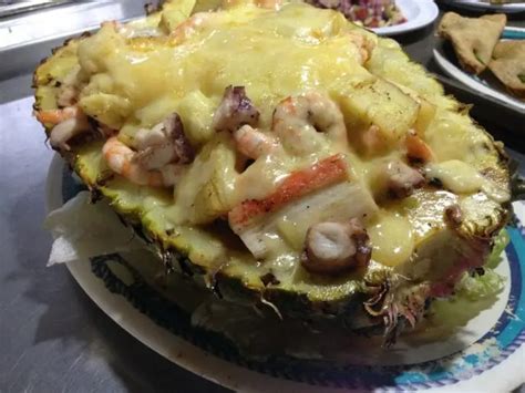 Piña gratinada de mariscos servida