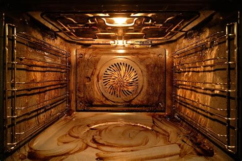 Interior de un horno muy sucio con restos de comida quemada