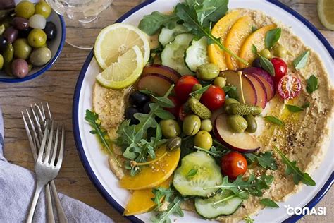 Platos con legumbres: hummus, ensalada y hamburguesas vegetales