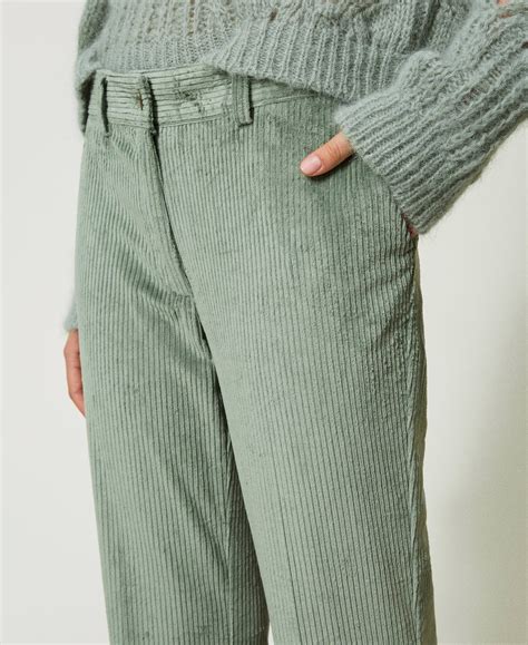 Mujer vistiendo pantalones de pana verdes en un look elegante