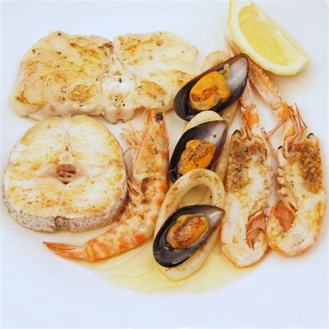 Parrillada de pescado y marisco servida con salsa