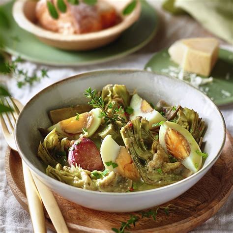 Plato servido de alcachofas guisadas al vino blanco decoradas con perejil y parmesano