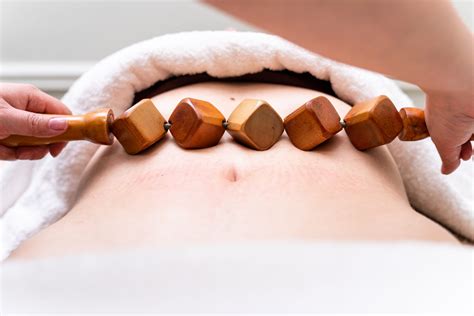 Mujer recibiendo tratamiento de maderoterapia abdominal para reducción de cintura