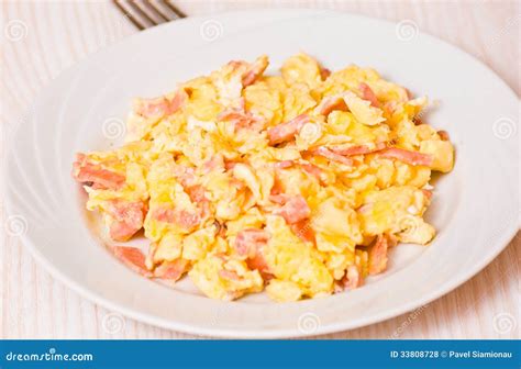 Plato terminado de revuelto de patatas con jamón y huevos fritos