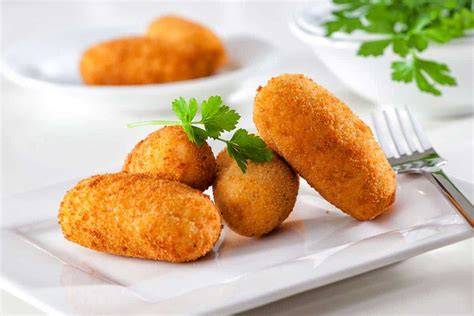 Croquetas de arroz con pollo doradas en un plato