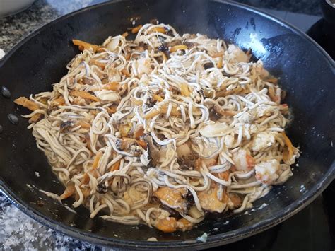 Gulas y gambas salteándose en una sartén