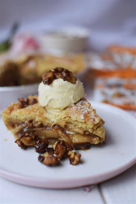 Rebanada de tarta de boniato con nueces caramelizadas y una cucharada de nata montada
