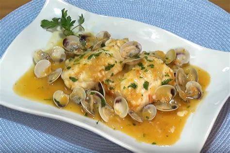 Plato de merluza a la marinera con almejas y perejil