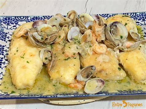 Merluza con almejas cocinándose en una sartén