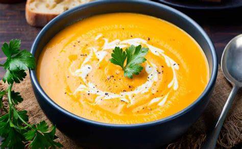 crema de calabaza servida en un tazón con un toque de crema