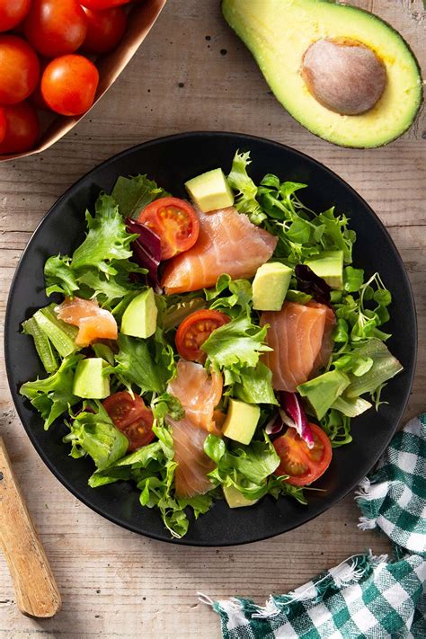 Ensalada fresca de canónigos, aguacate y salmón ahumado servida en un bol elegante