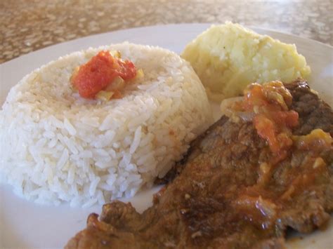 Plato de bistec encebollado con arroz y plátano frito