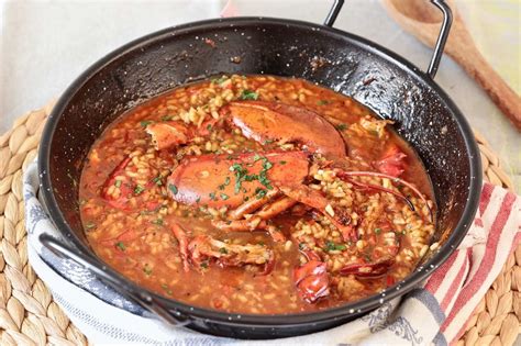Arroz cocinándose en una paellera con bogavante
