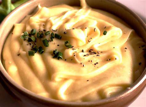 Mayonesa de naranja en un bol con ingredientes frescos