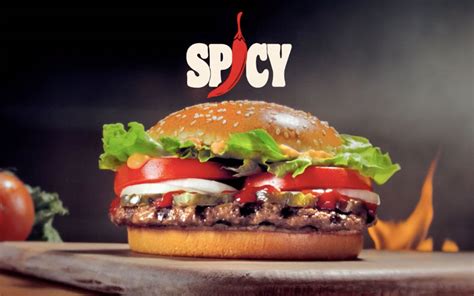 Primer plano de una Whopper picante con salsa sriracha goteando sobre los ingredientes frescos