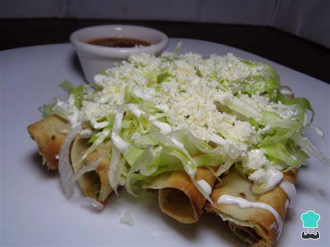 Tacos de pollo dorados en una sartén con especias
