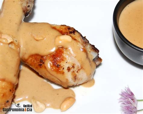 Pollo con salsa de cacahuete decorado con crujientes de albahaca