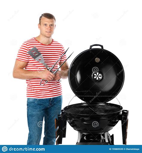 Hombre limpiando una parrilla con espátula metálica