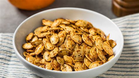 Tarro de cristal hermético lleno de semillas de calabaza tostadas para snack