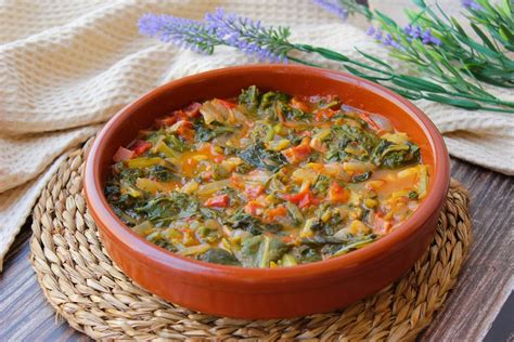 Plato de guiso de acelgas servido en cazuela de barro
