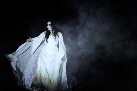 Representación artística de la Llorona con una vestimenta blanca y su rostro cubierto