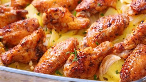 Alitas de pollo y patatas horneándose