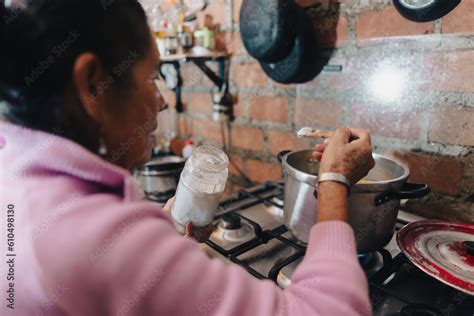 Mujer mayor cocinando empanadillas en una cocina tradicional
