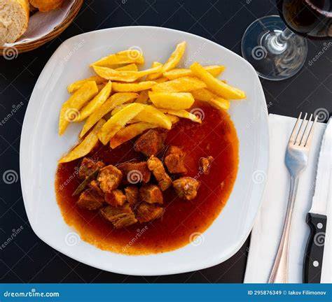 Plato de cazón guisado servido con acompañamientos tradicionales
