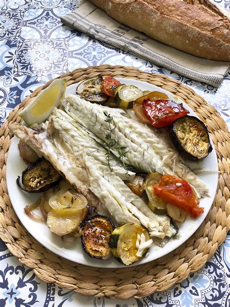 Plato final de lubina al horno servido con guarnición
