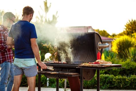 hombre cocinando barbacoa con amigos
