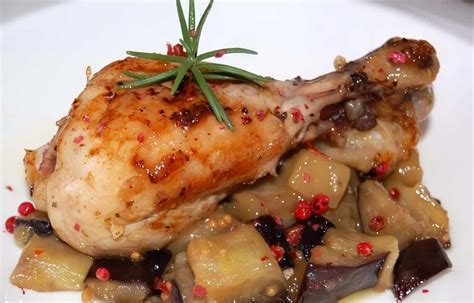 plato de pollo con berenjenas y papas servido en una mesa