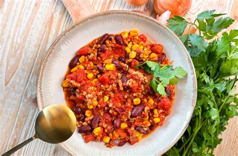 mesa puesta con chili sin carne y diversos acompañamientos