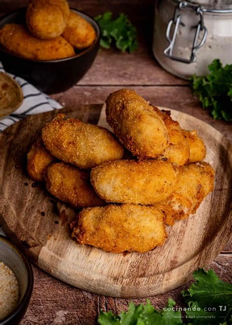 Plato de croquetas de pollo doradas y crujientes servidas en una bandeja