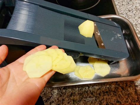 Proceso de corte de patatas con mandolina para un grosor uniforme