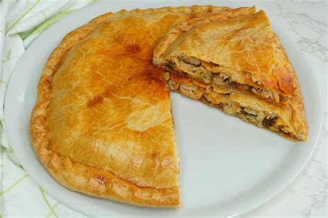 Empanada de bacalao cortada en porciones mostrando el relleno