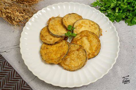 plato de berenjenas rebozadas servidas con salsa casera