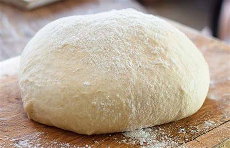 Masa de pan leudando dentro de un horno apagado con un paño húmedo